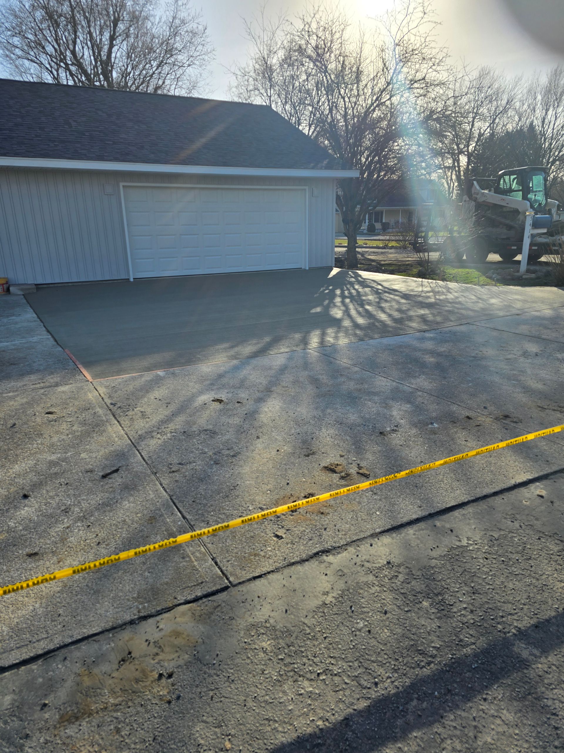 A garage with two garage doors is sitting next to a concrete driveway.