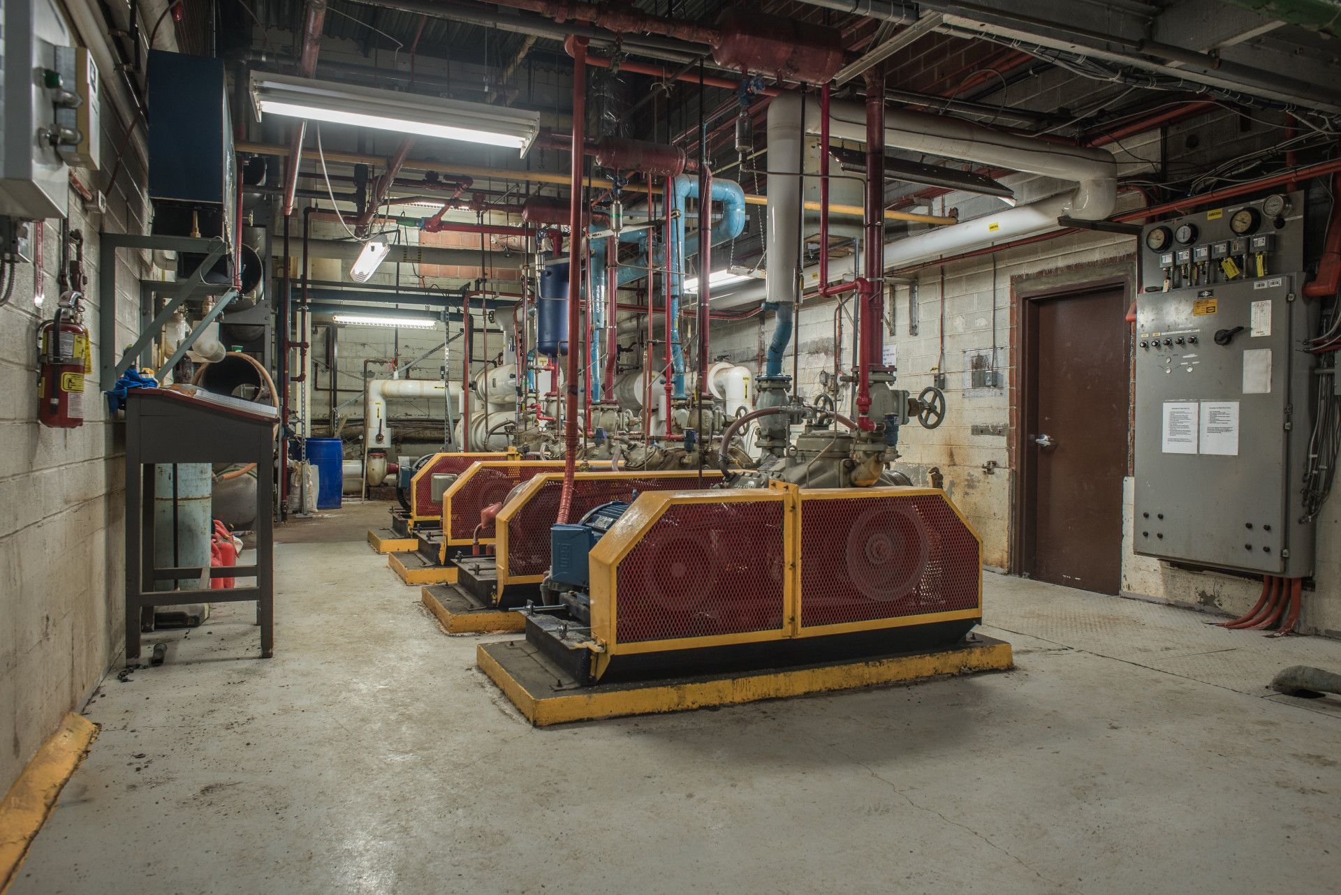 A room with industrial pumps and pipes, likely a utility or mechanical room.