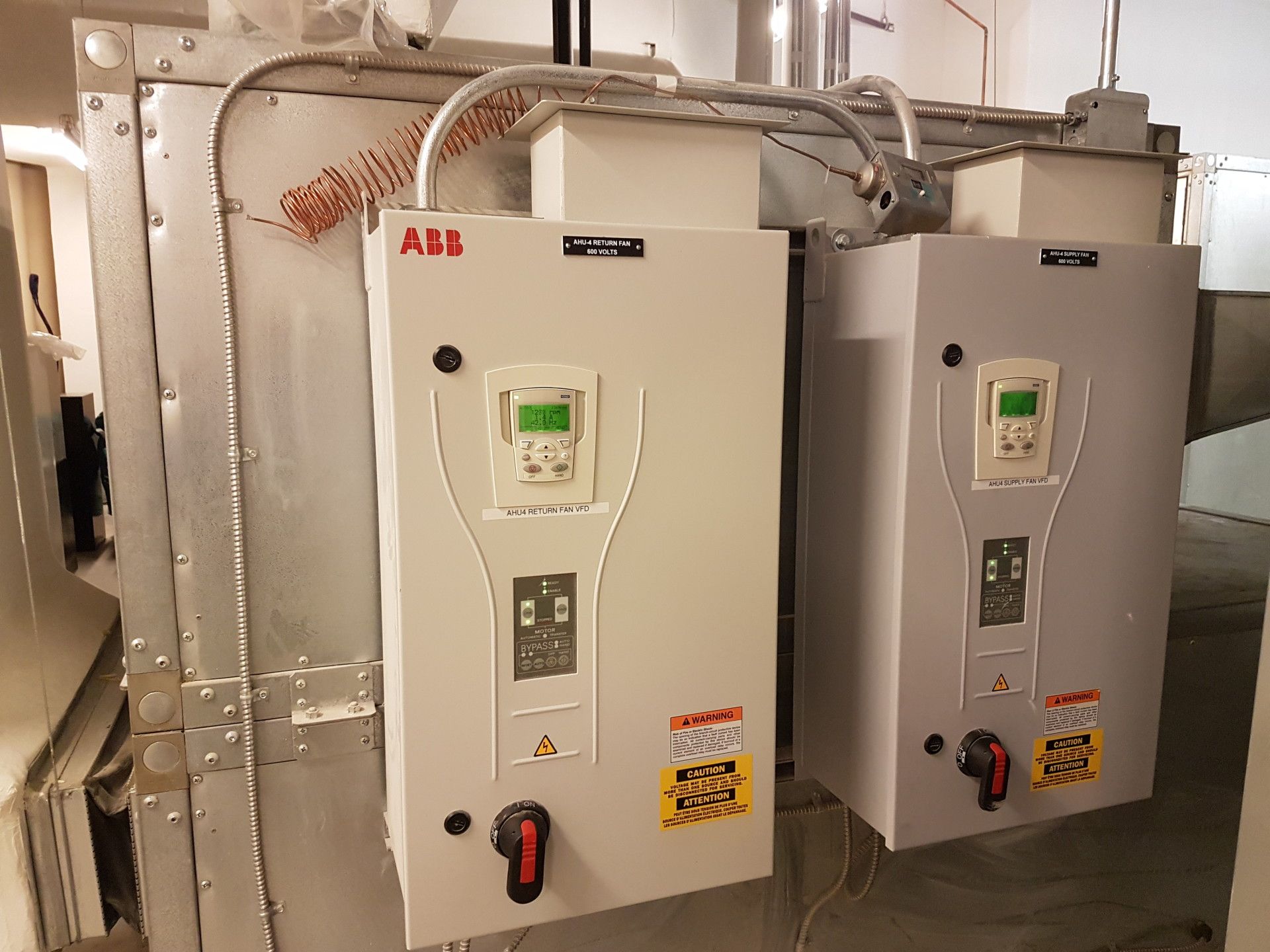 Two ABB industrial control panels with displays, mounted on metal equipment.