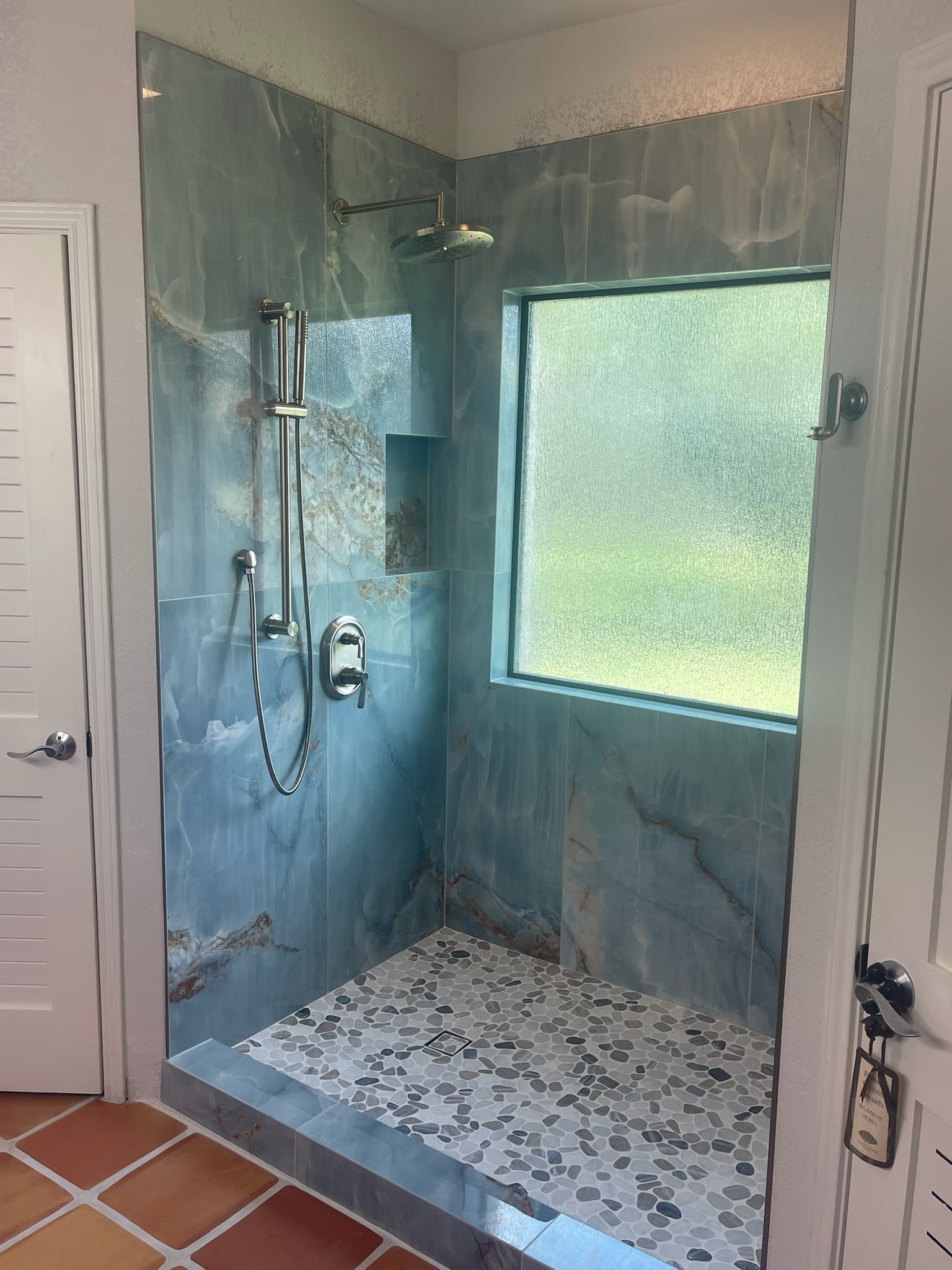 Well water system with blue and white tanks, PVC piping, and a pump in a wood-framed space.