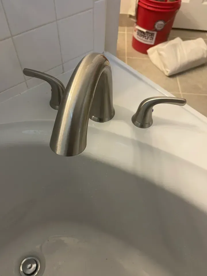 Brushed nickel bathtub faucet with two handles.