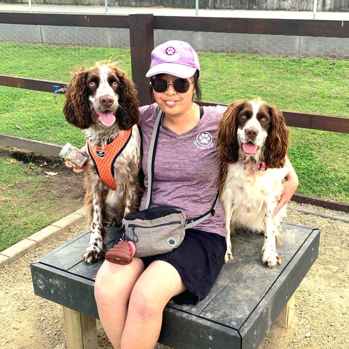Mea of Purrs and Waggs sitting next to two dogs.