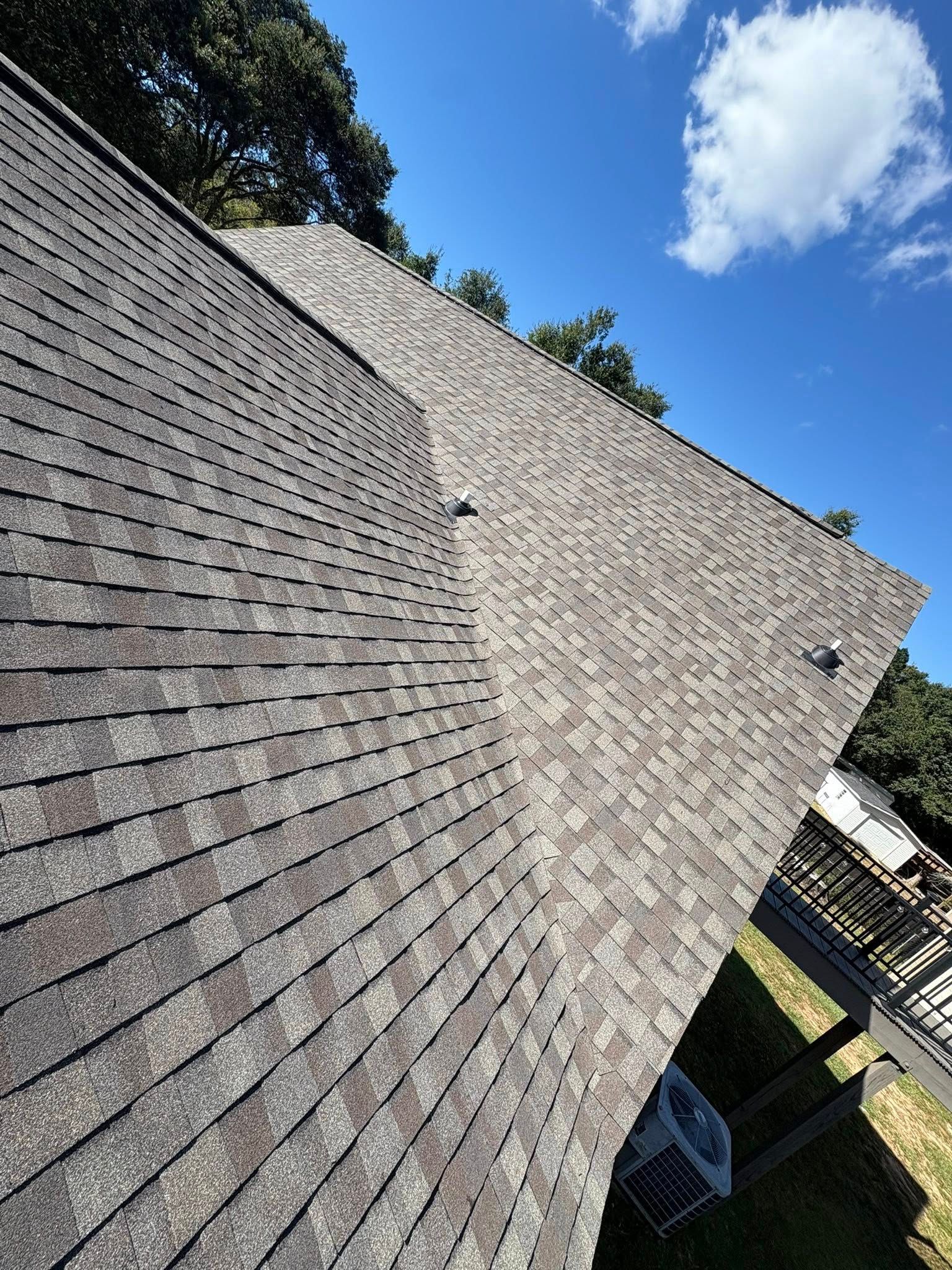 Gray asphalt shingle roof on a sunny day.