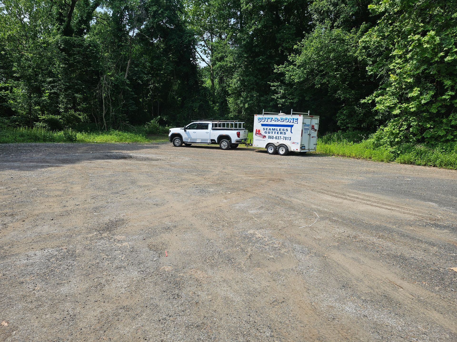A person is cleaning a gutter of leaves on a roof.