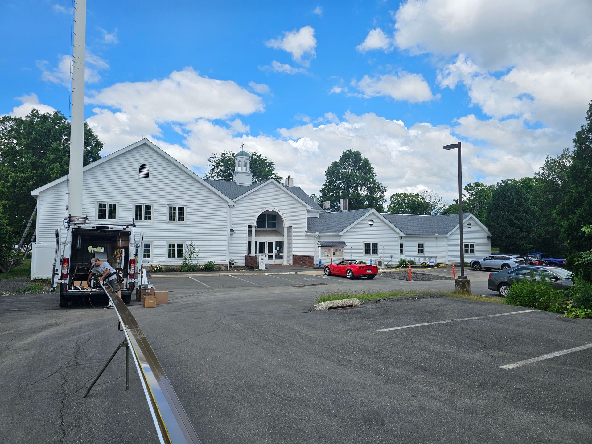 A man wearing a hard hat is fixing a gutter on a roof.