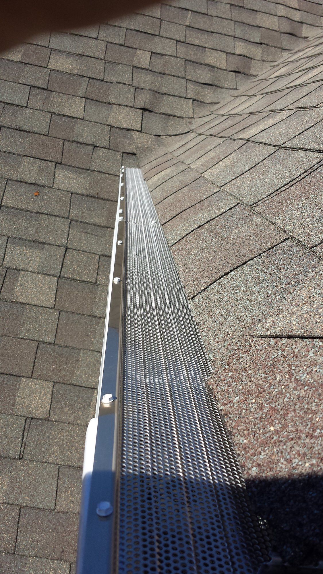 A close up of a gutter on a brick roof.