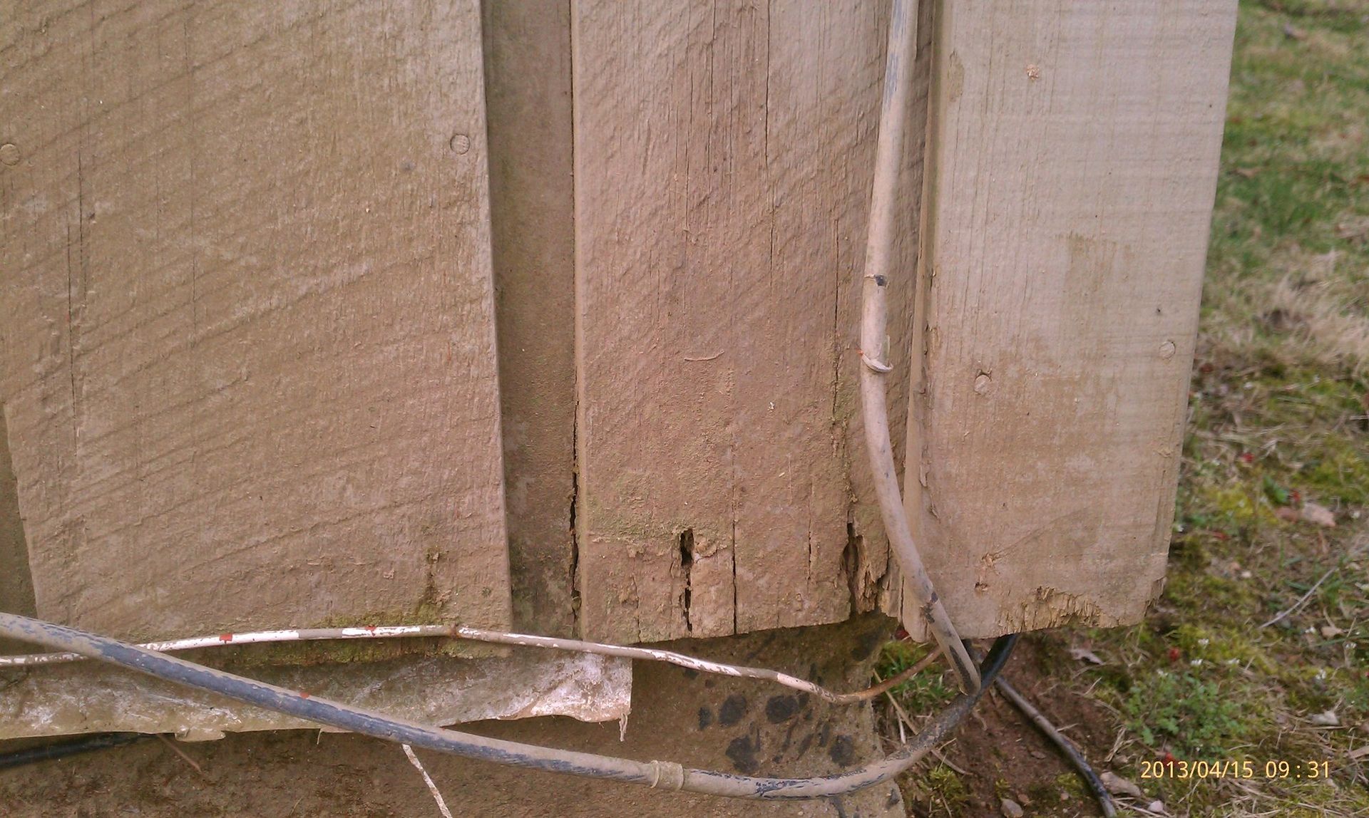 A concrete wall with a few wires coming out of it