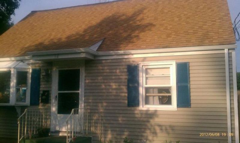 A house with a brown roof and blue shutters