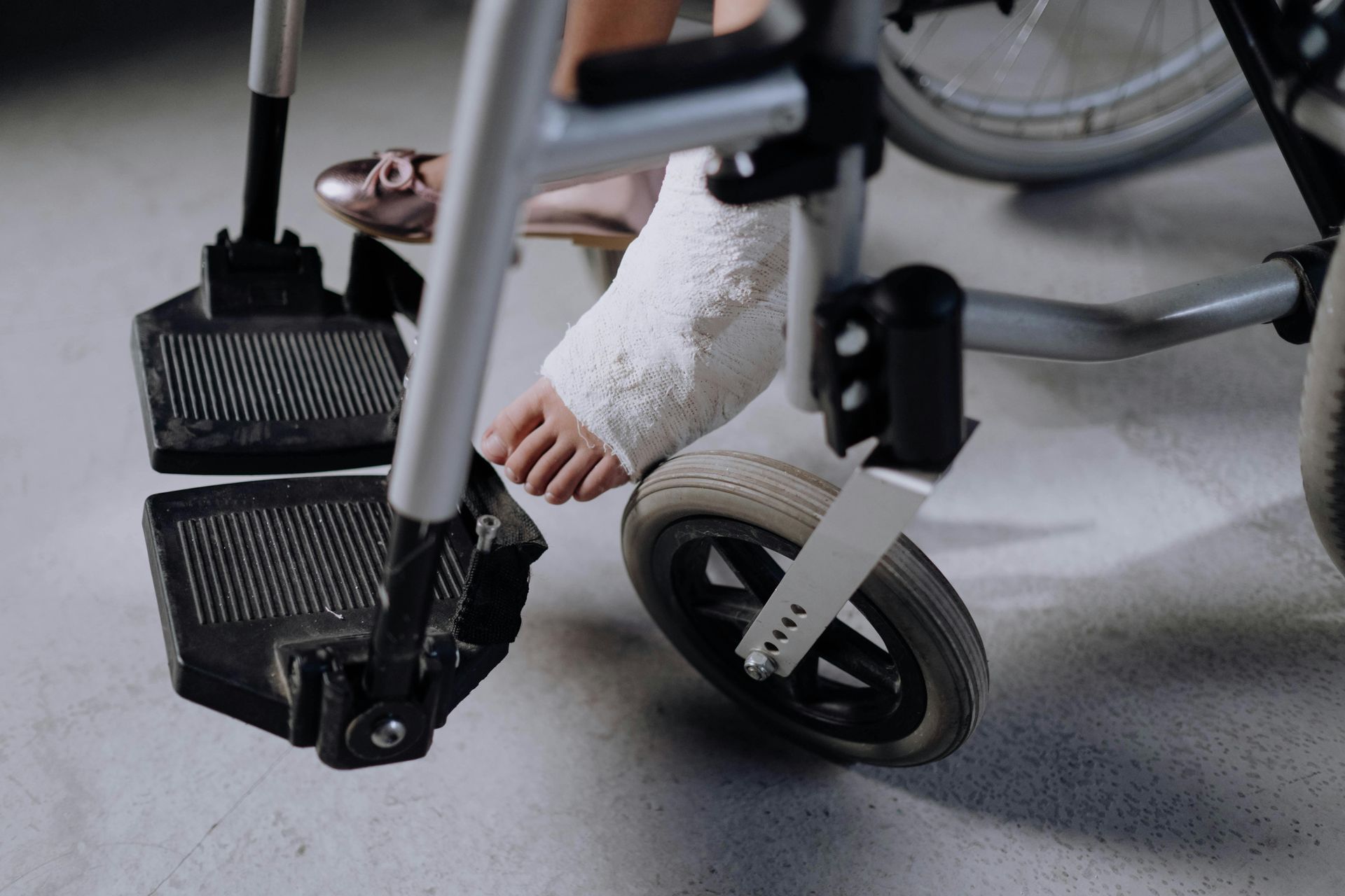 A person with a cast on their foot is sitting in a wheelchair.