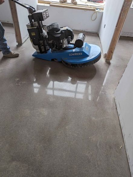 A machine is polishing a concrete floor in a room.