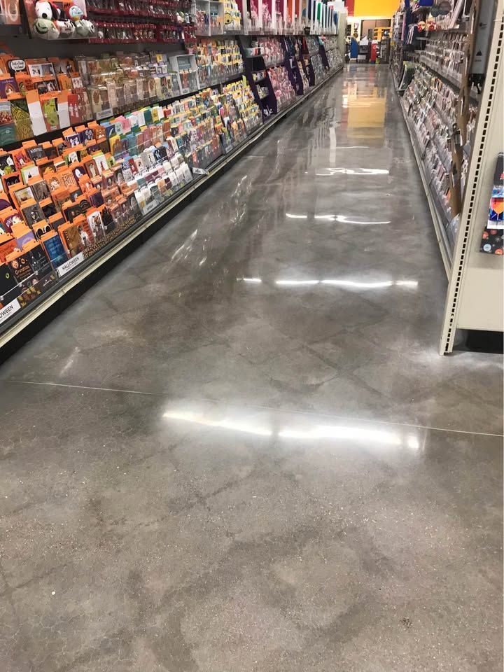 A long aisle in a grocery store with a shiny concrete floor.