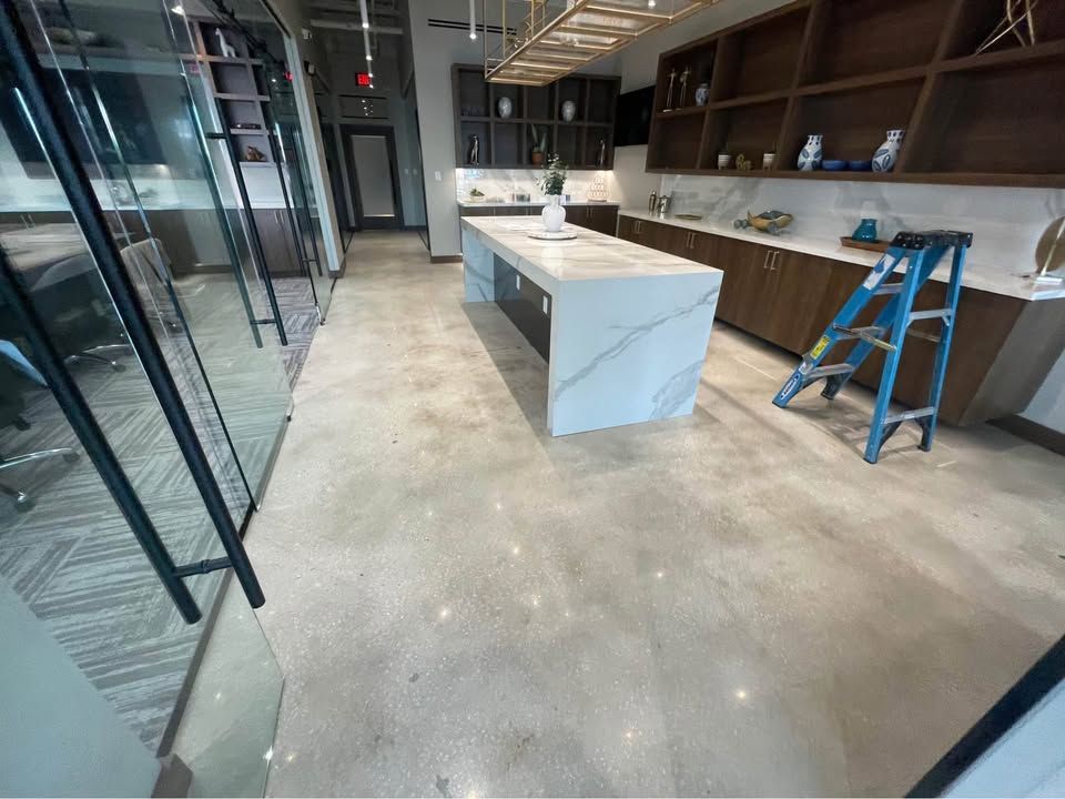 A kitchen with a large island and a ladder on the floor.