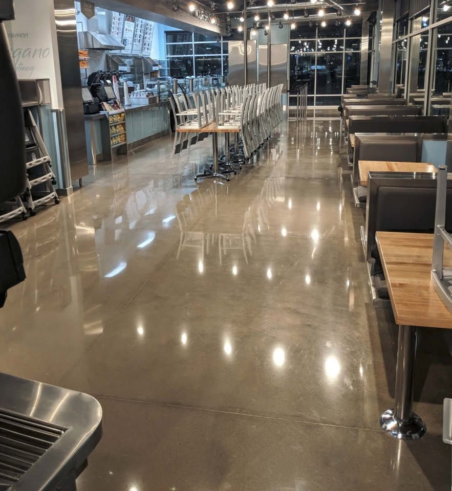 A long aisle in a grocery store with a shiny concrete floor.