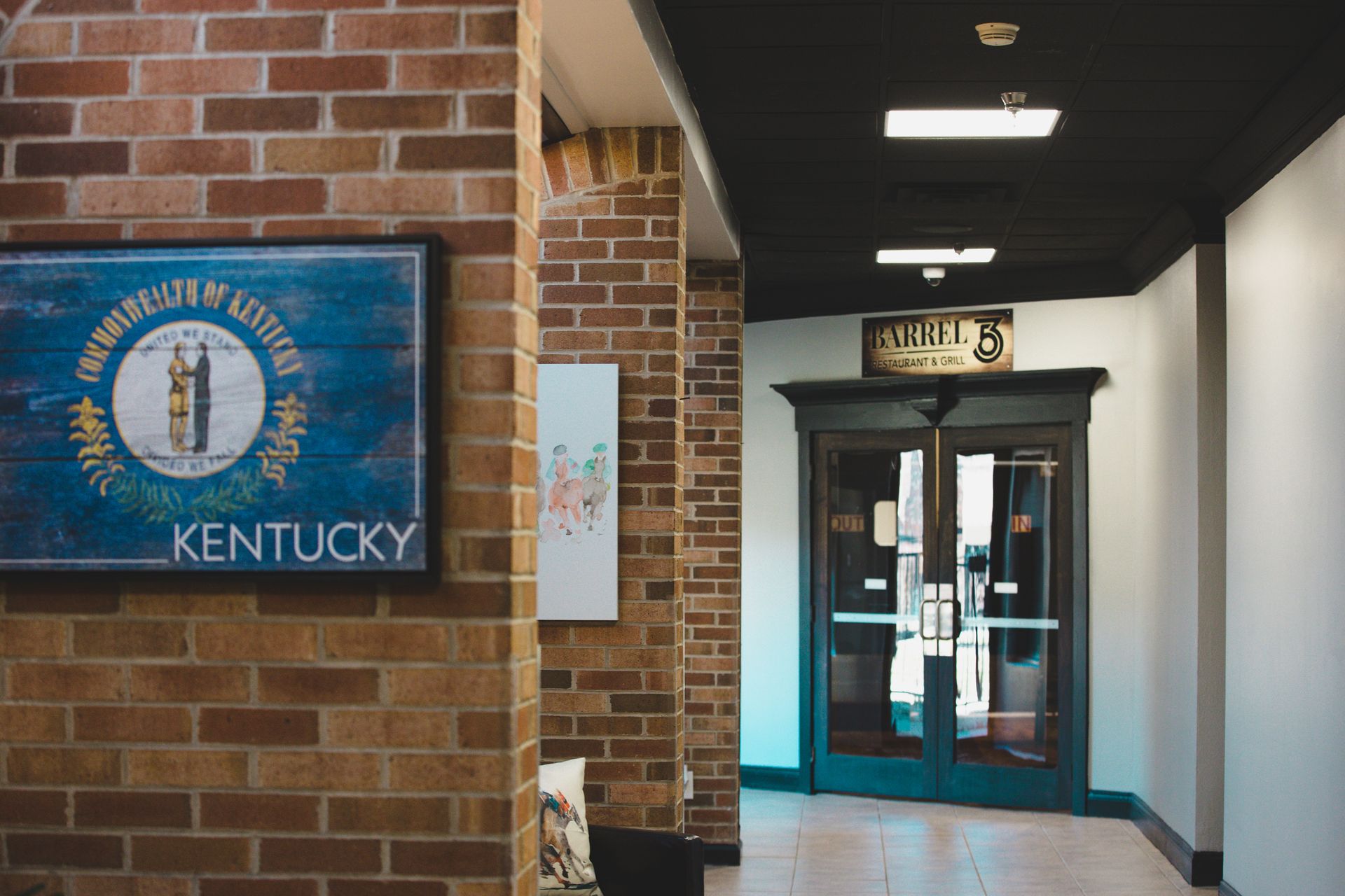 A hallway with a brick wall and a sign that says kentucky on it.