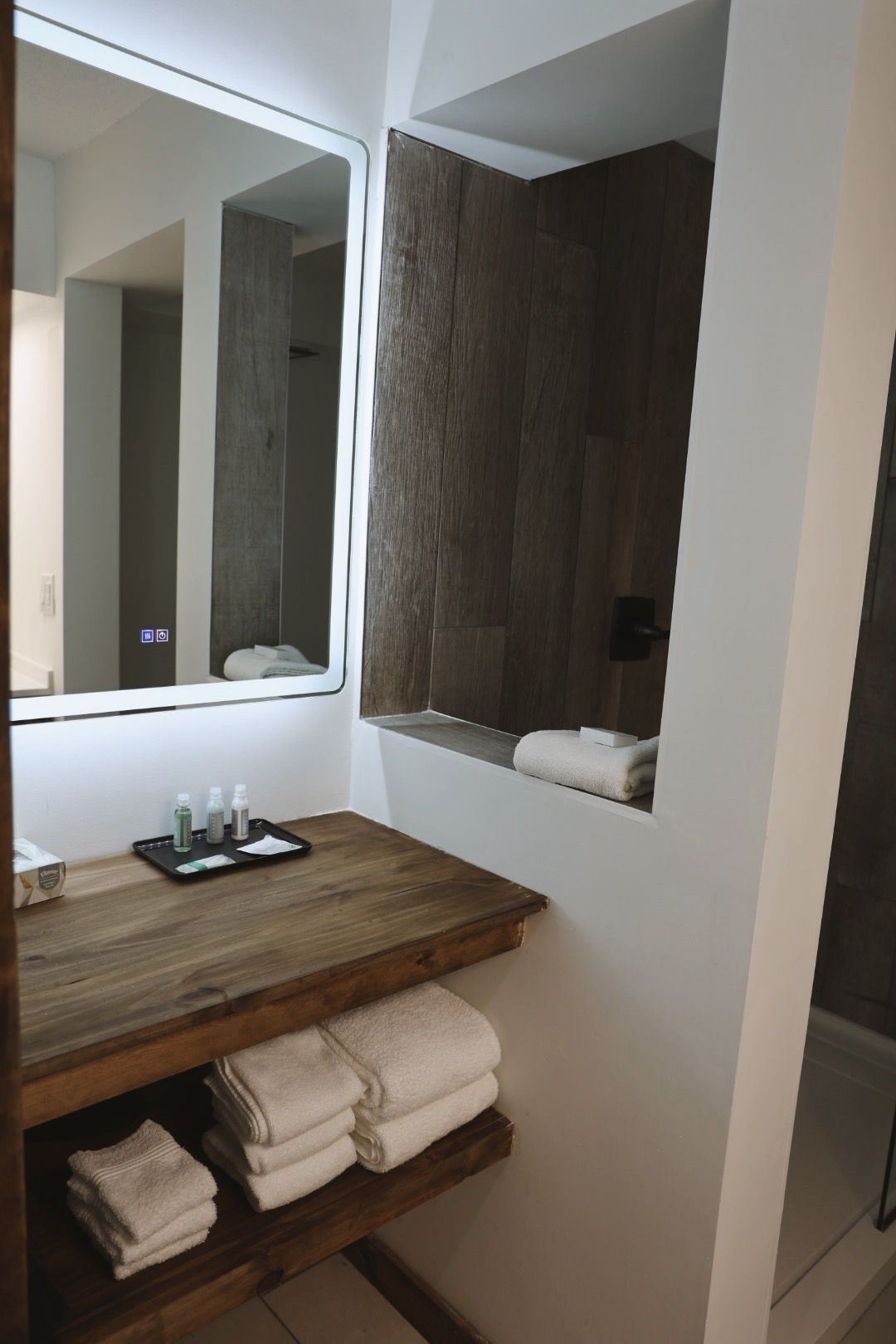 A bathroom with a wooden counter top and a mirror
