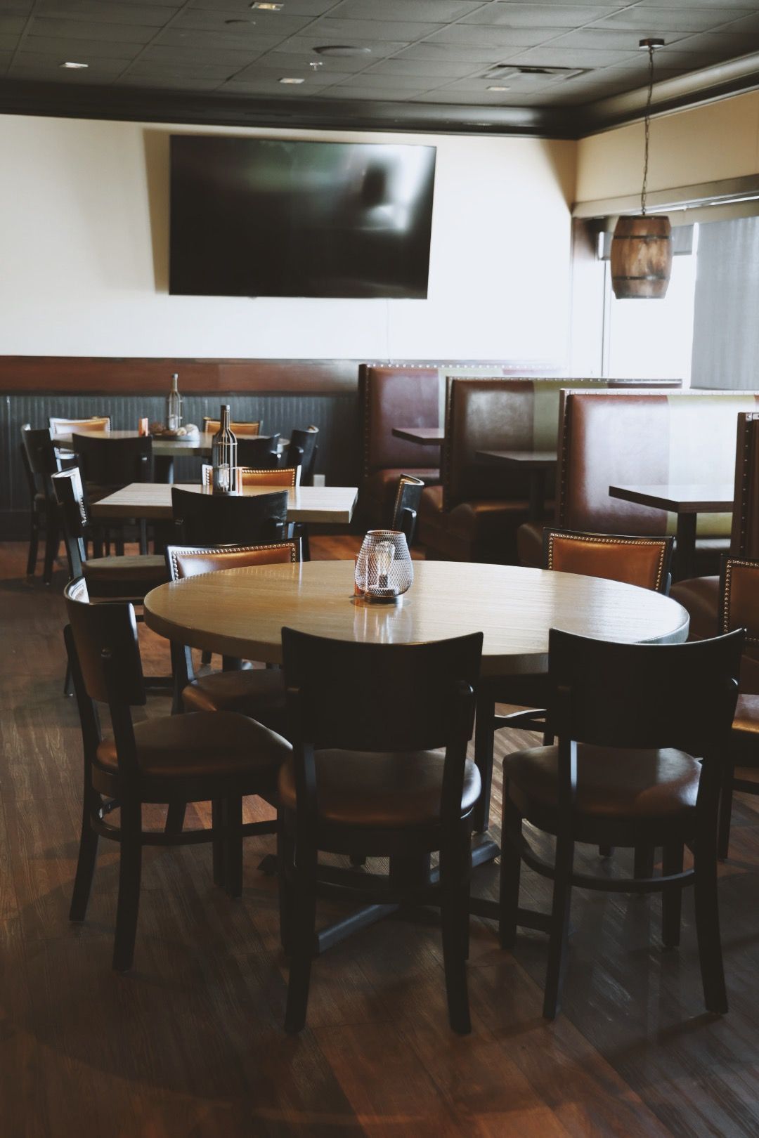 A restaurant with tables and chairs and a flat screen tv on the wall