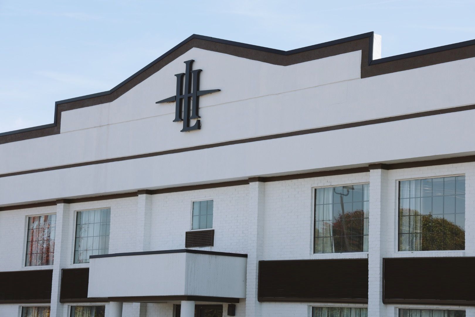 A white building with a roof that has the letter h on it