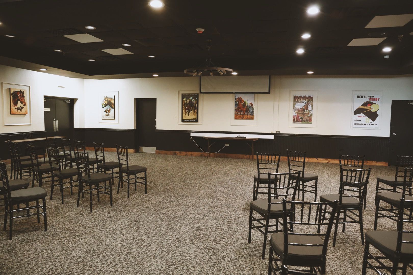 A large room filled with chairs and a projector screen.