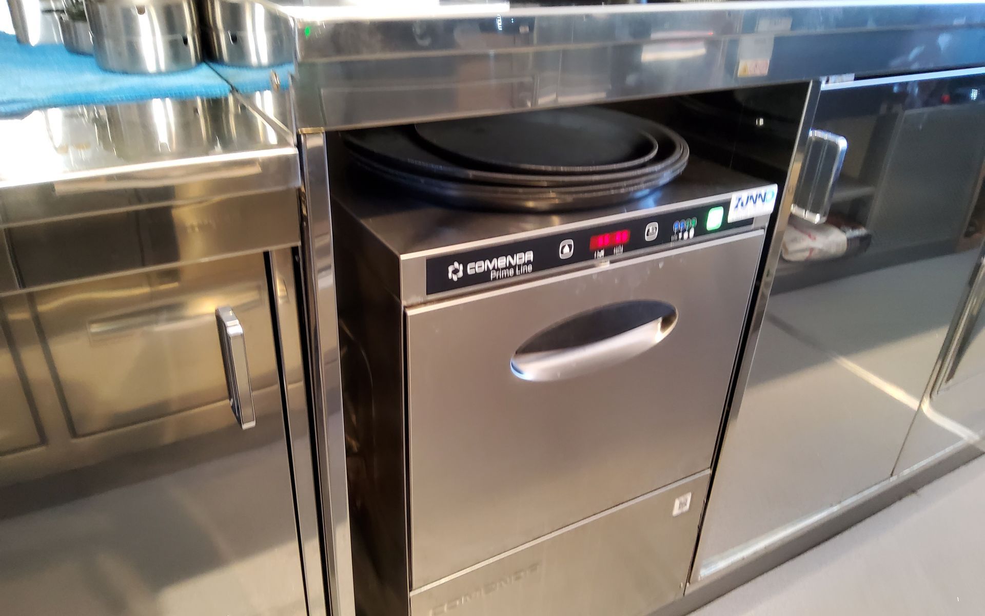 Lavastoviglie commerciale in acciaio inox in un ambiente cucina.