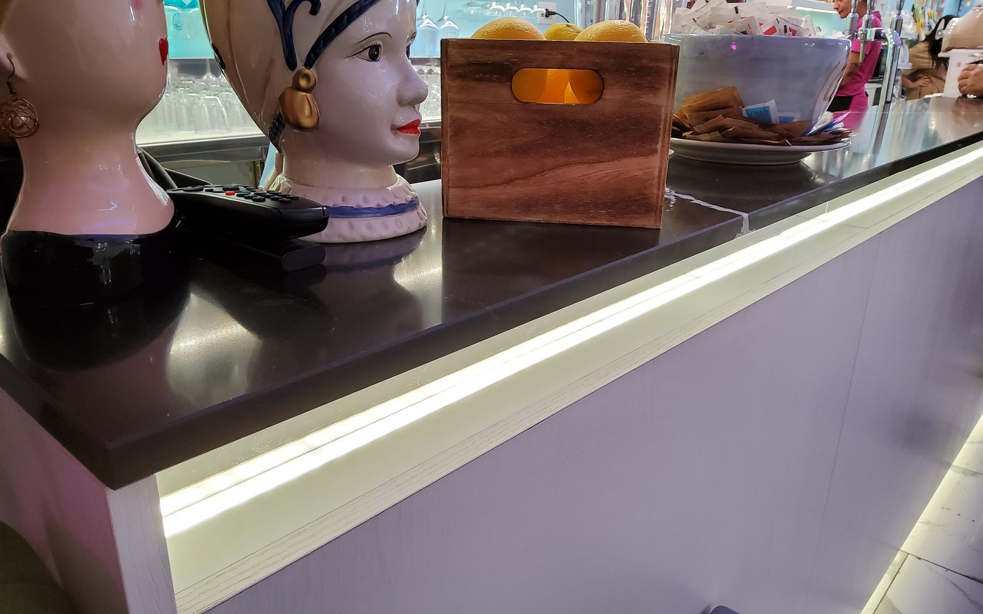 Bancone bar con elementi decorativi e illuminazione da incasso.