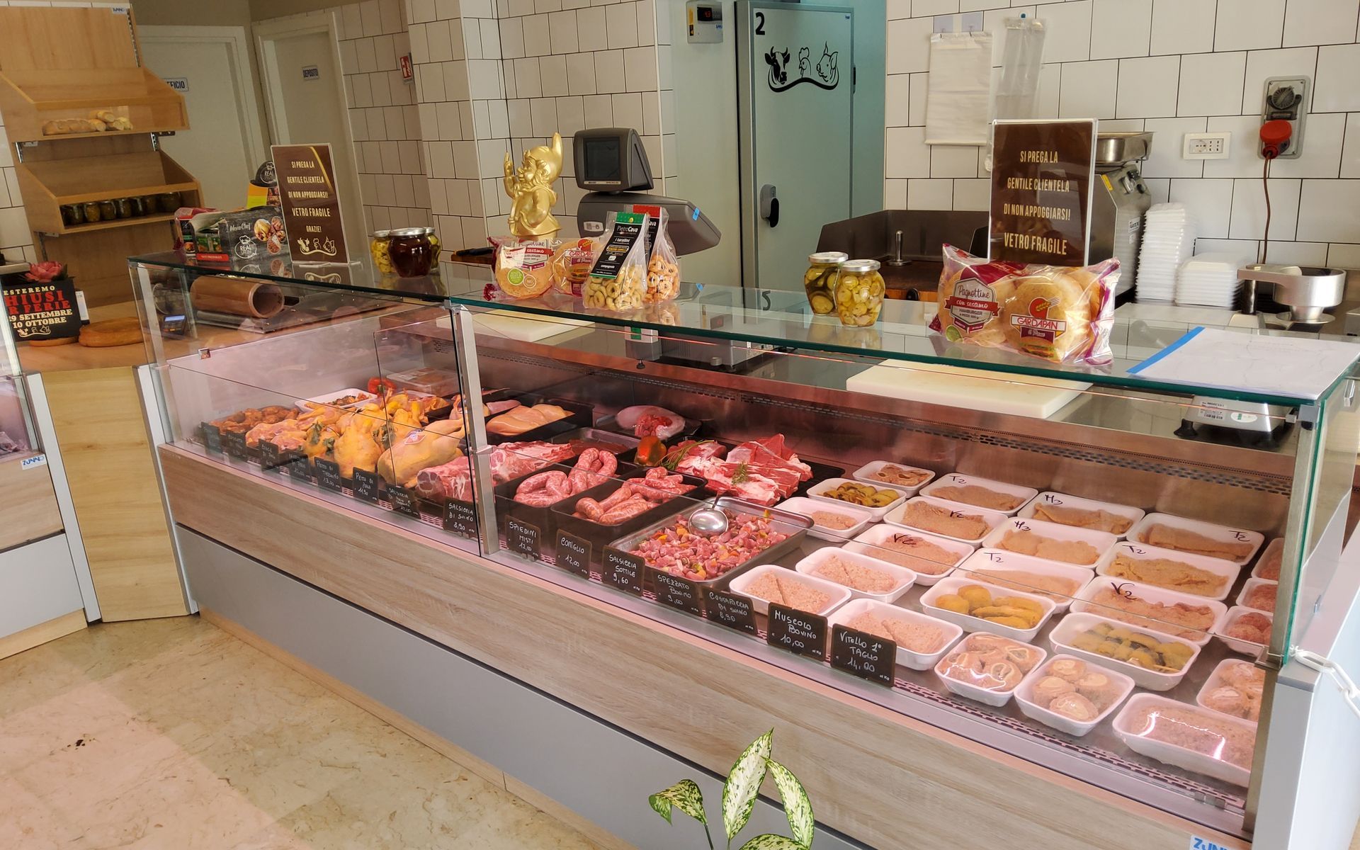 Vetrina per la carne in una macelleria, che espone vari tagli di carne e cibi preparati.