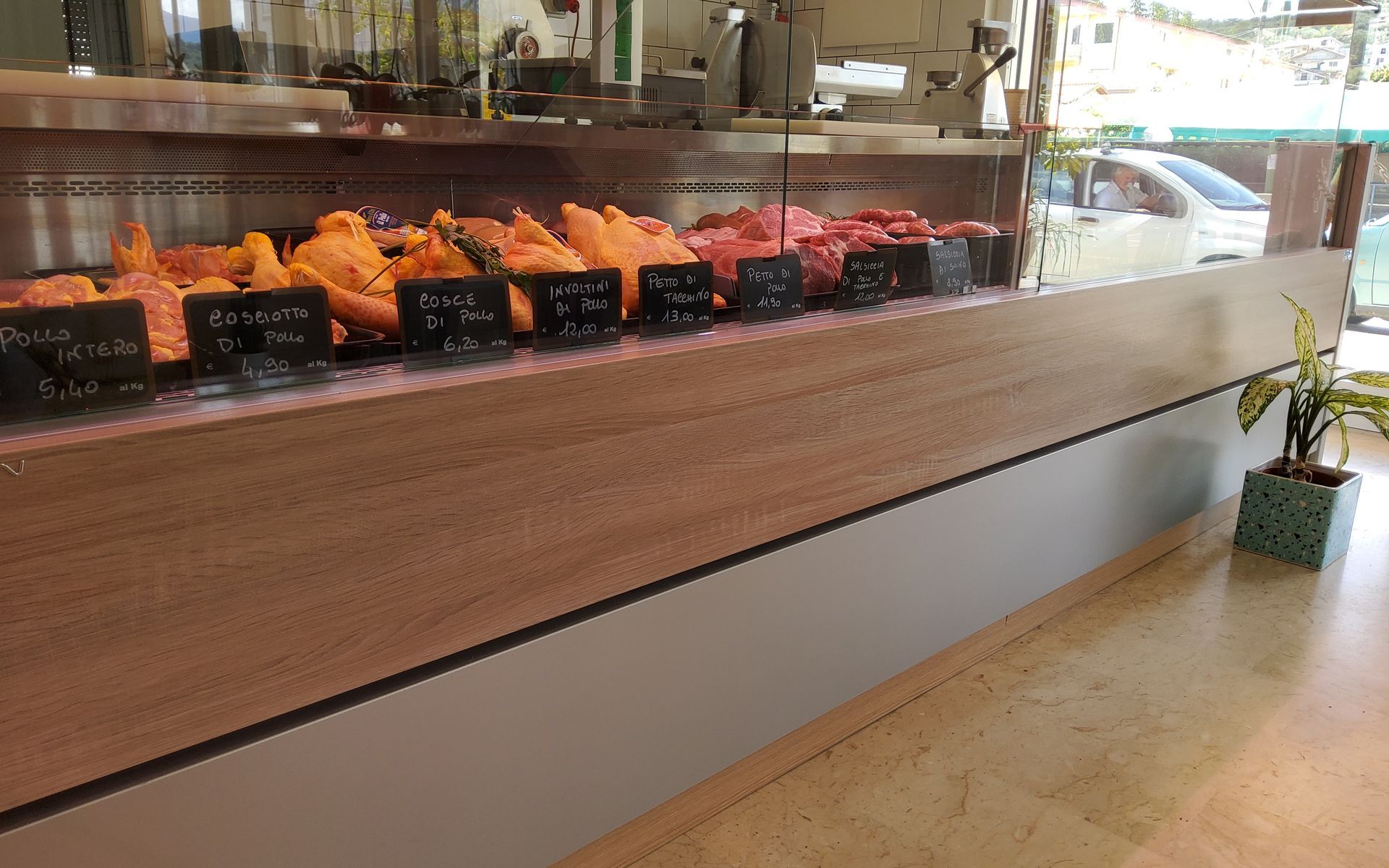 Vetrina per la carne in una macelleria, vari tagli di carne con etichette.