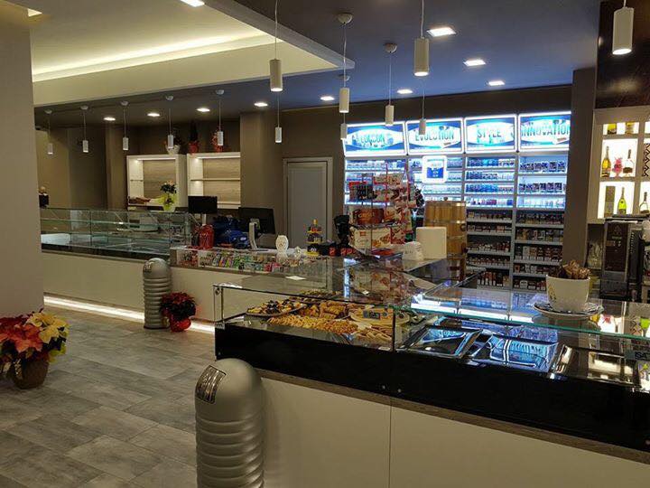 Interno di un moderno minimarket, che espone prodotti da forno, snack, tabacco e bevande.