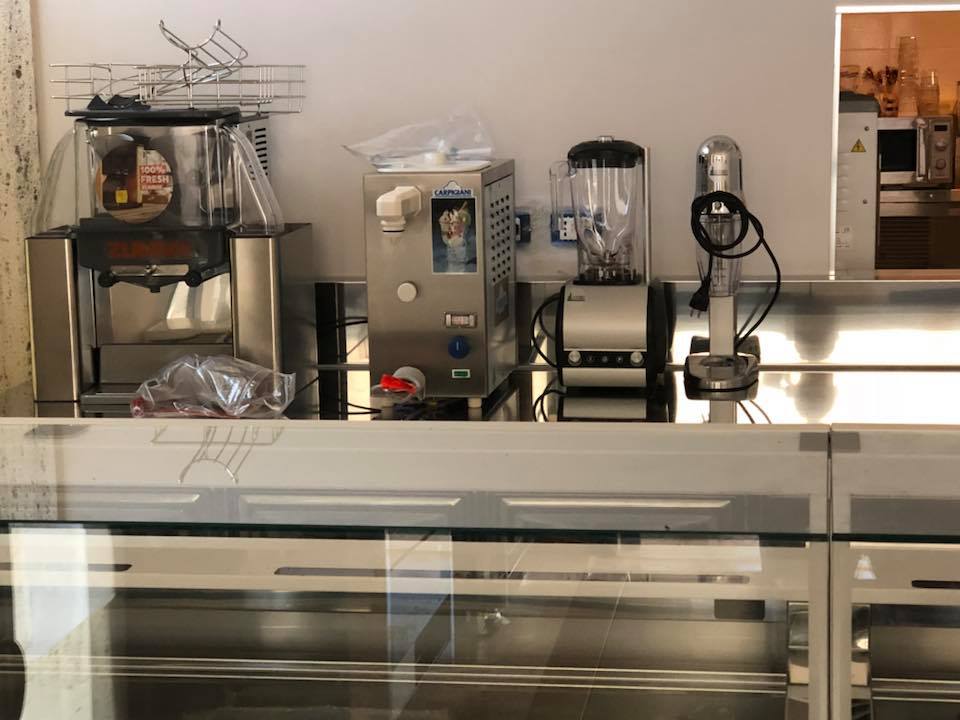 Elettrodomestici da cucina in acciaio inossidabile su un bancone: macchina per il ghiaccio, gelatiera, frullatore.