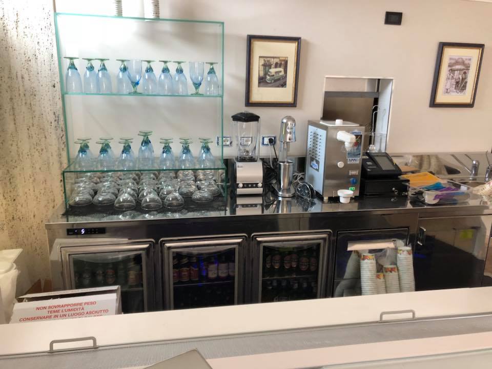 Bar con bicchieri, spine per la birra e unità di refrigerazione.