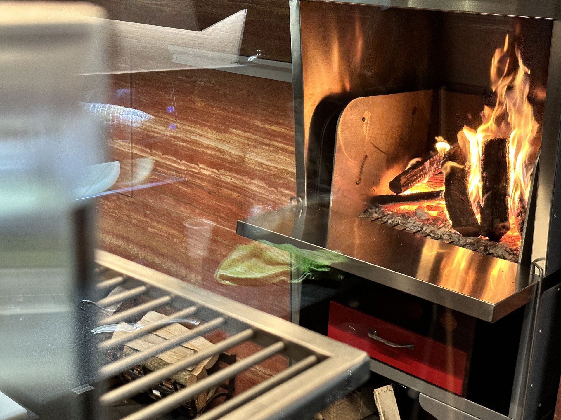 Camino con fiamme e ceppi ardenti, interno in acciaio inox.