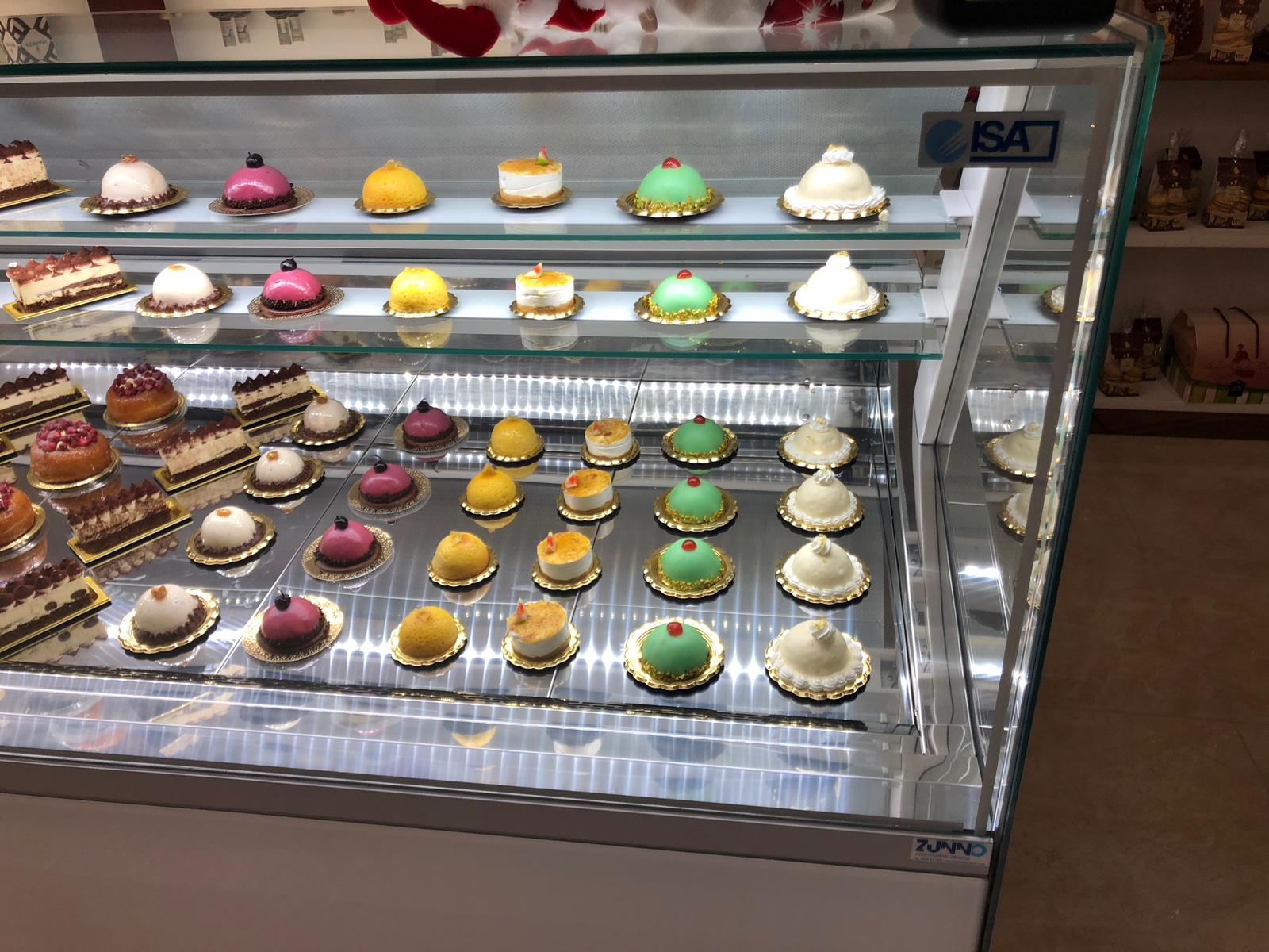 Vetrina con vari pasticcini colorati esposti in una panetteria.