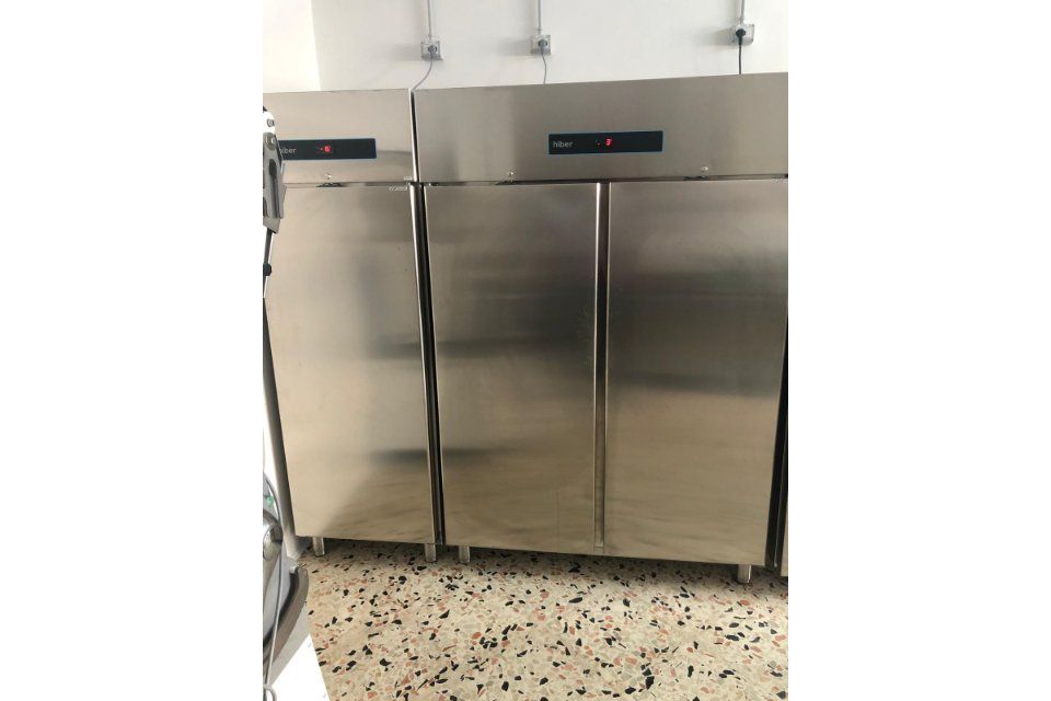 Tre frigoriferi commerciali in acciaio inossidabile in una cucina.