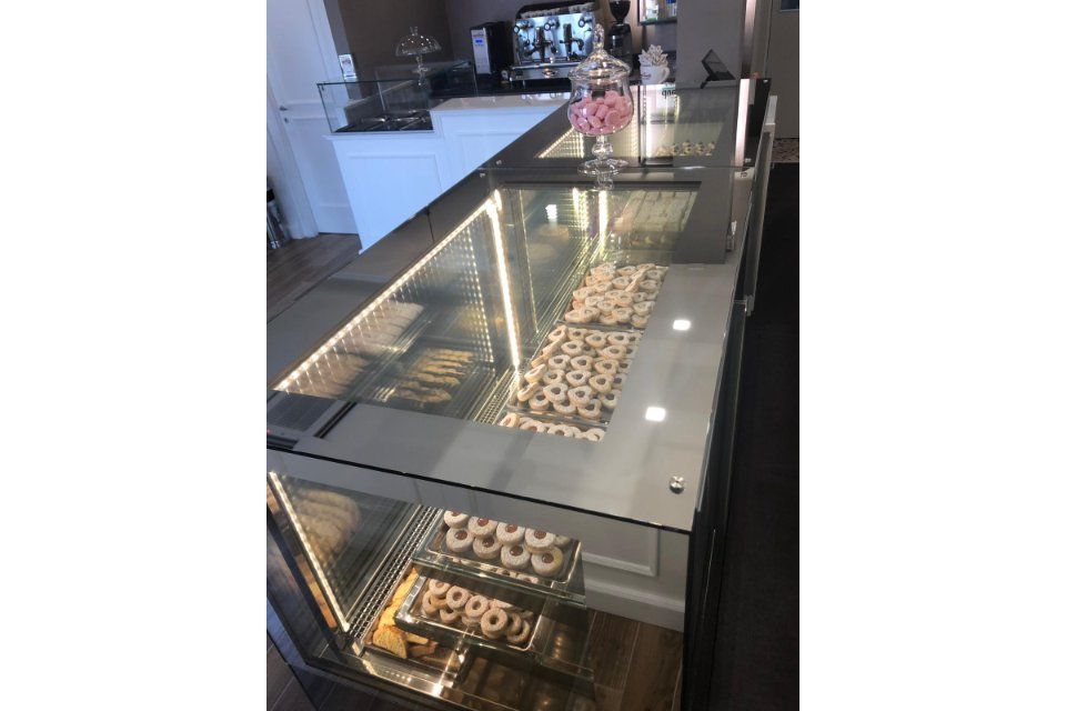 Vetrina piena di ciambelle e pasticcini in una panetteria.