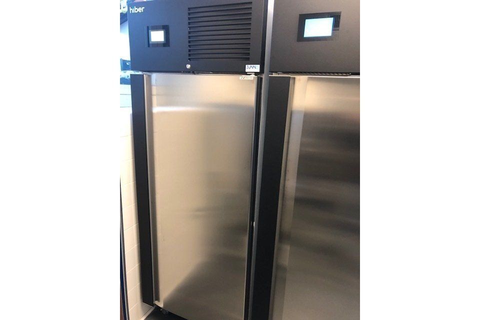 Due frigoriferi in acciaio inossidabile con telai delle porte neri, sormontati da apparecchiature nere.