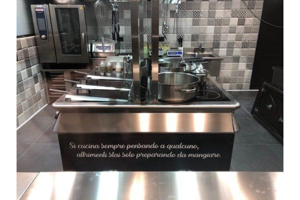 Isola da cucina commerciale con attrezzatura per cucinare; messaggio sulla parte anteriore: