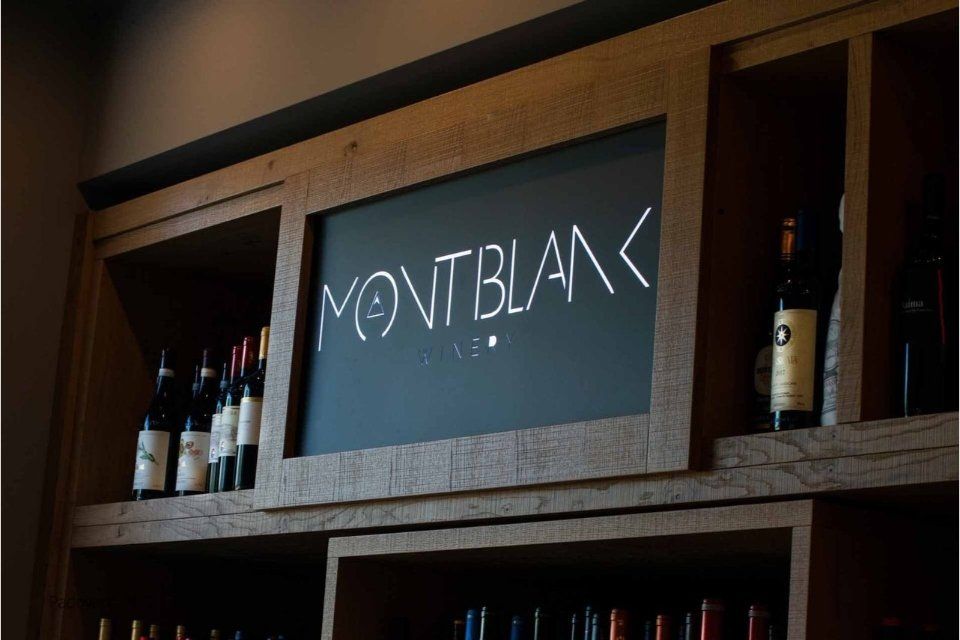 Portabottiglie in legno con bottiglie e una lavagna con la scritta