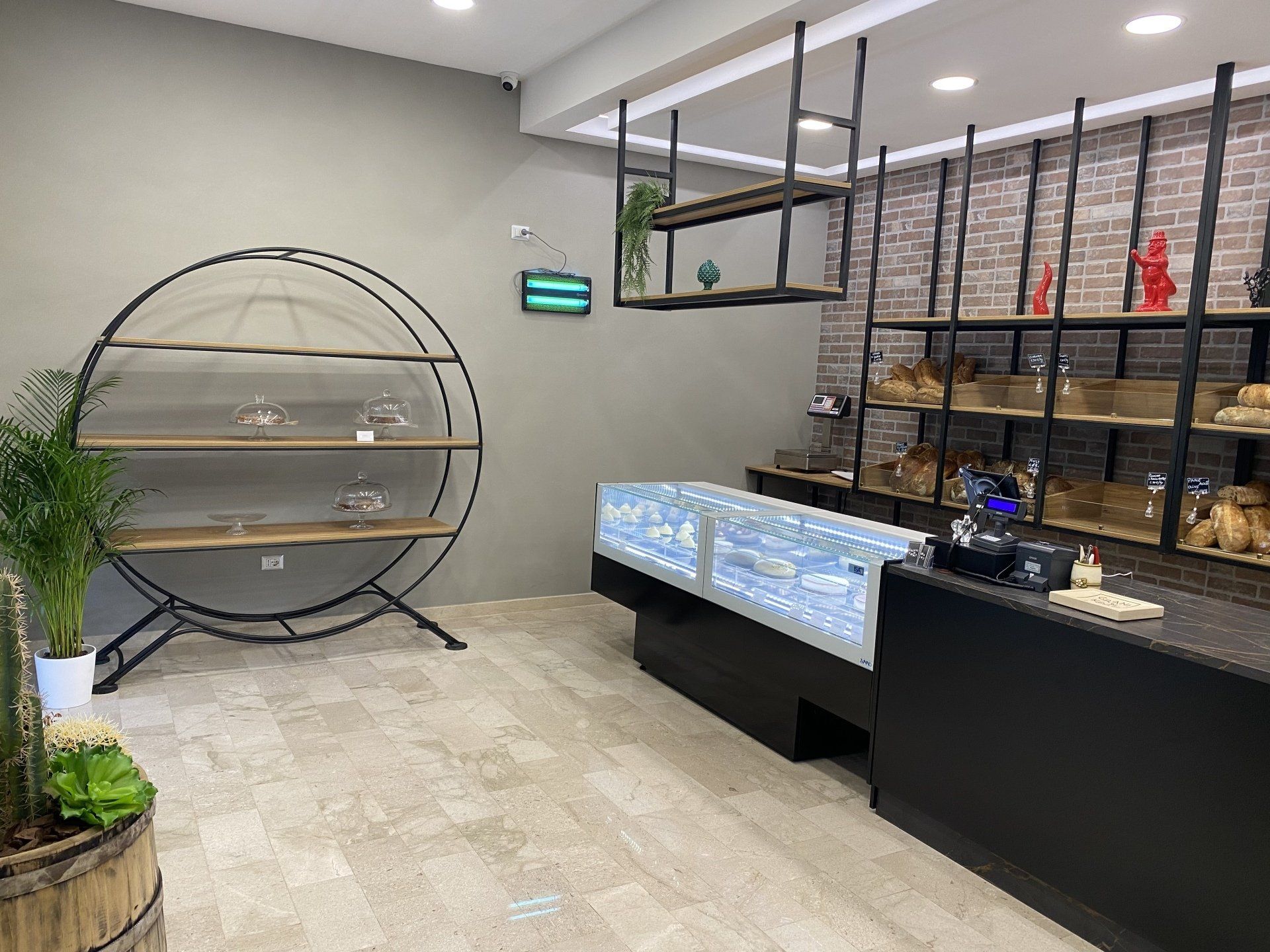 Interno di un panificio con vetrine, scaffali e vari prodotti da forno.