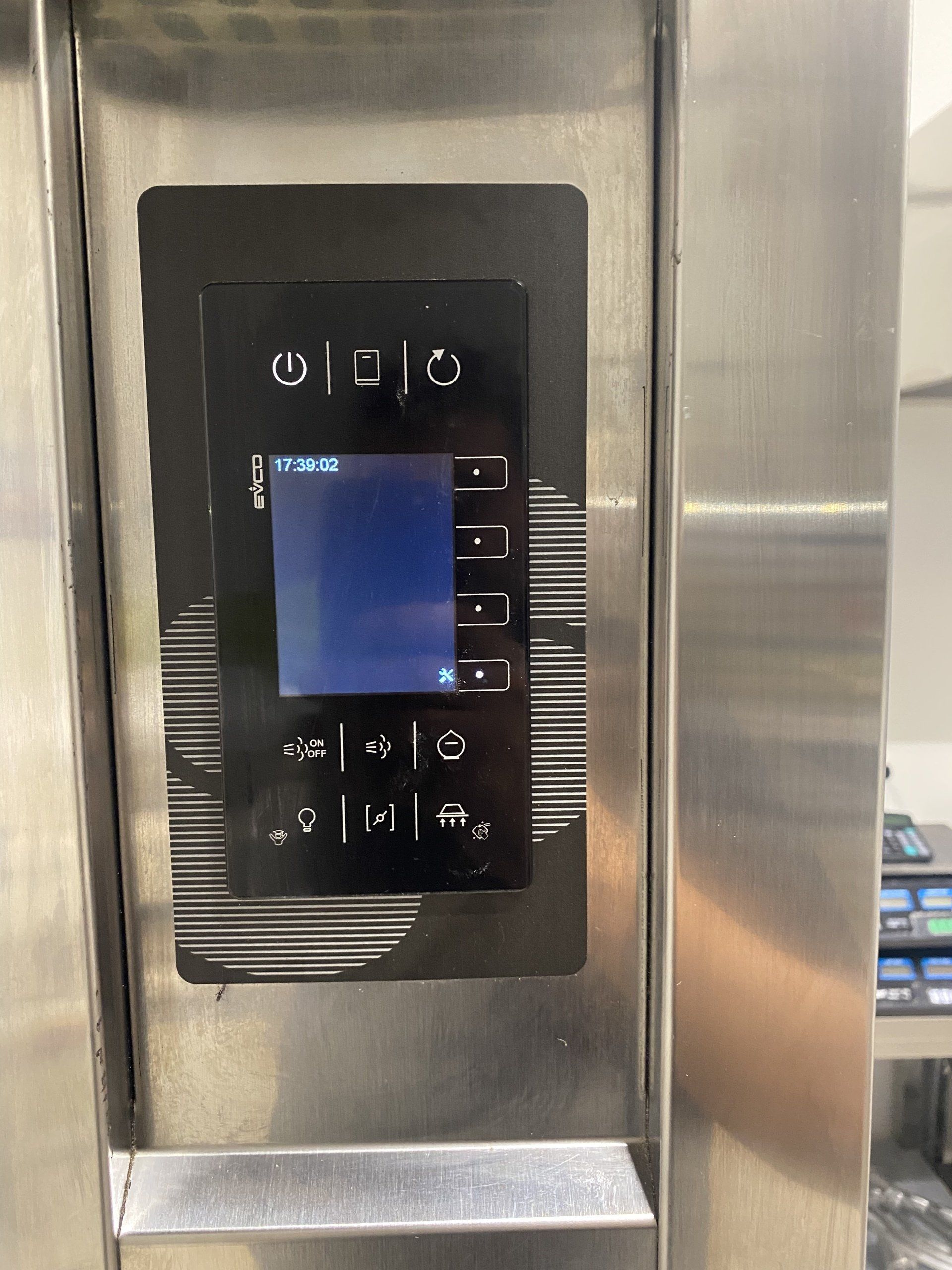 Pannello di controllo touch screen nero su elettrodomestico in acciaio inossidabile.