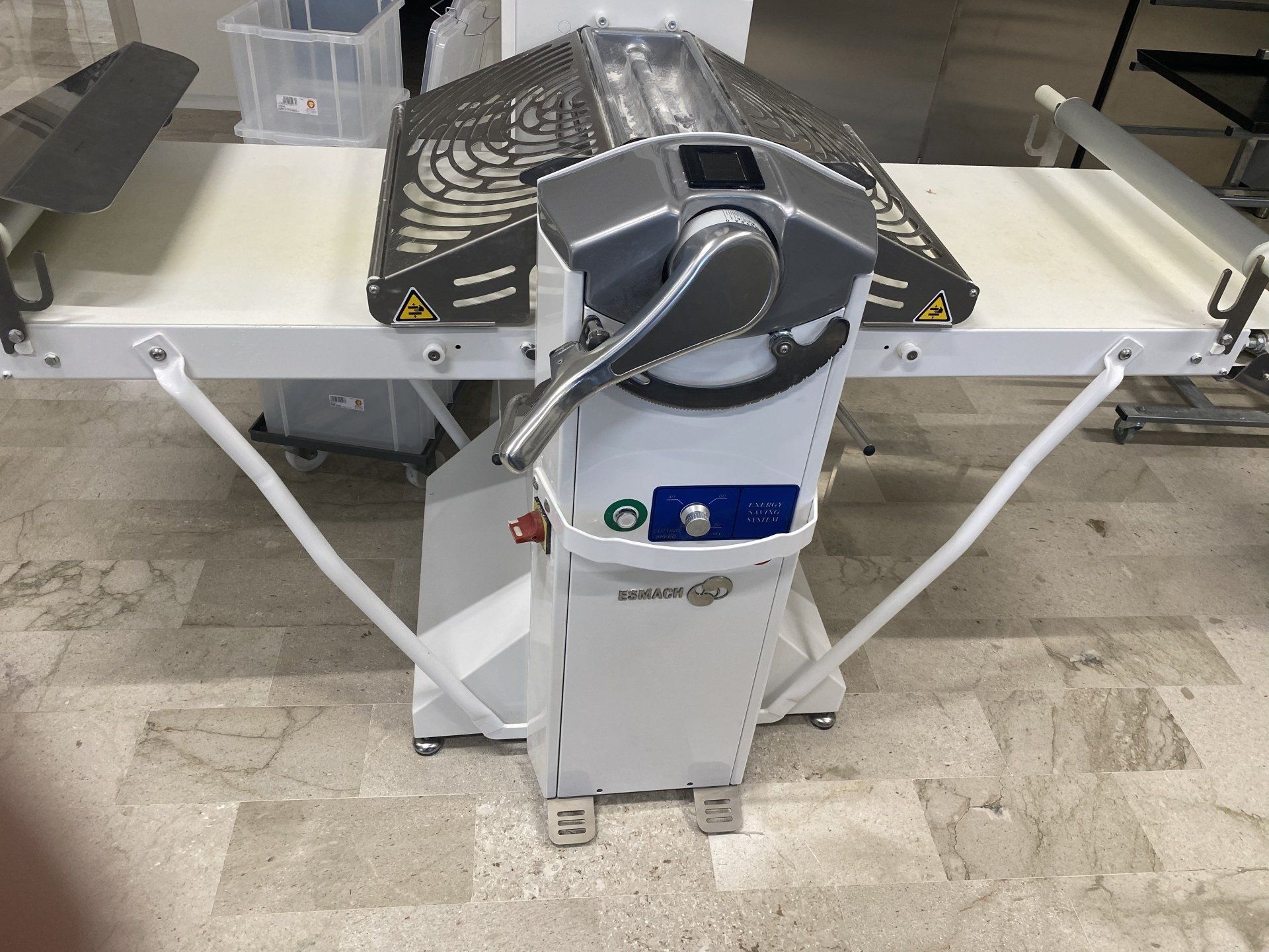 Sfogliatrice per pasta di pane bianco, maniglie anteriori, nastri trasportatori laterali.