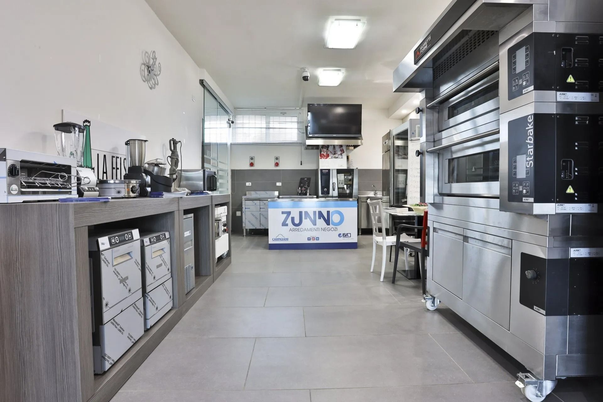 Uno showroom di elettrodomestici da cucina con forni, mixer e altre attrezzature in esposizione.
