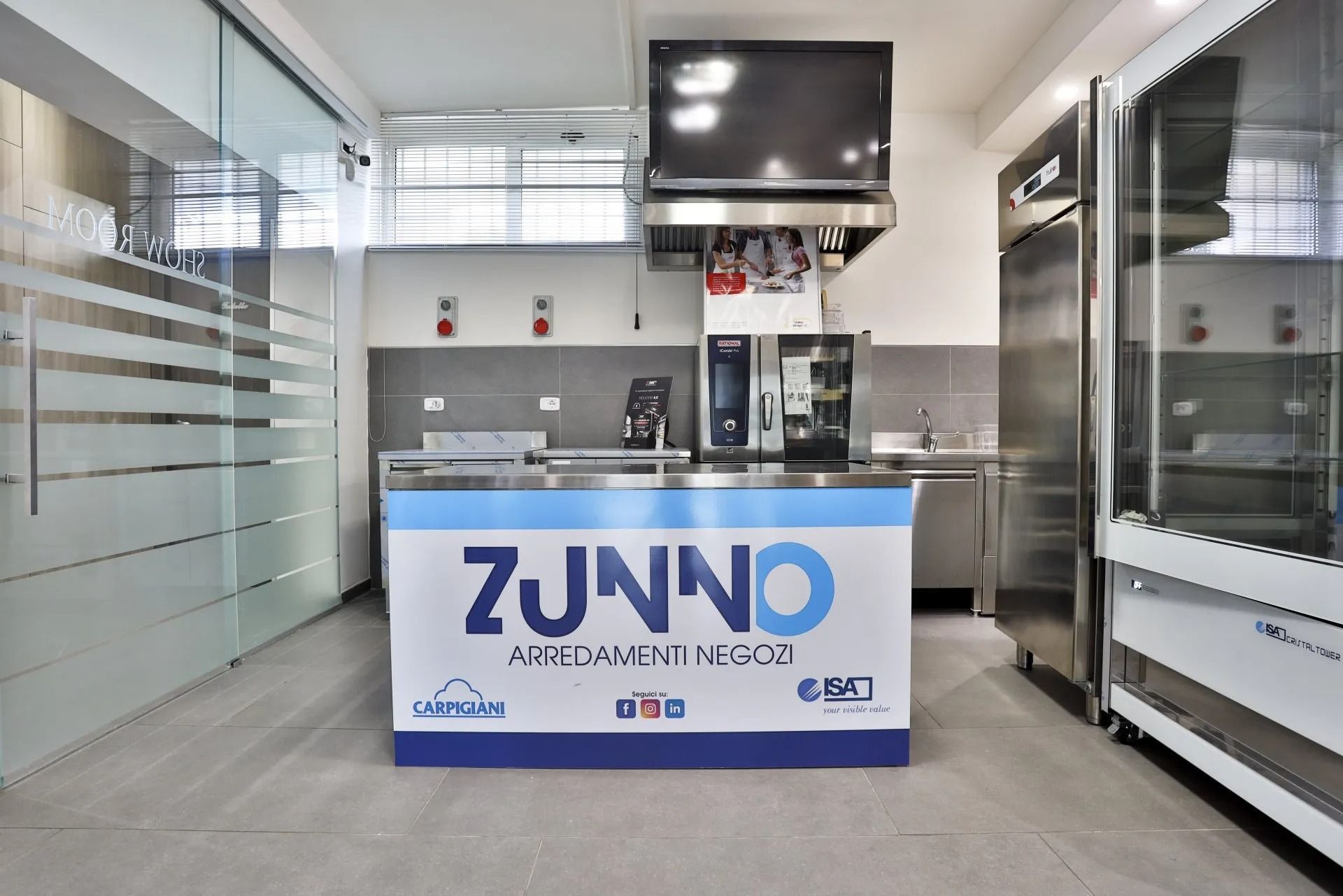 Cucina con elettrodomestici in acciaio inox e bancone con logo