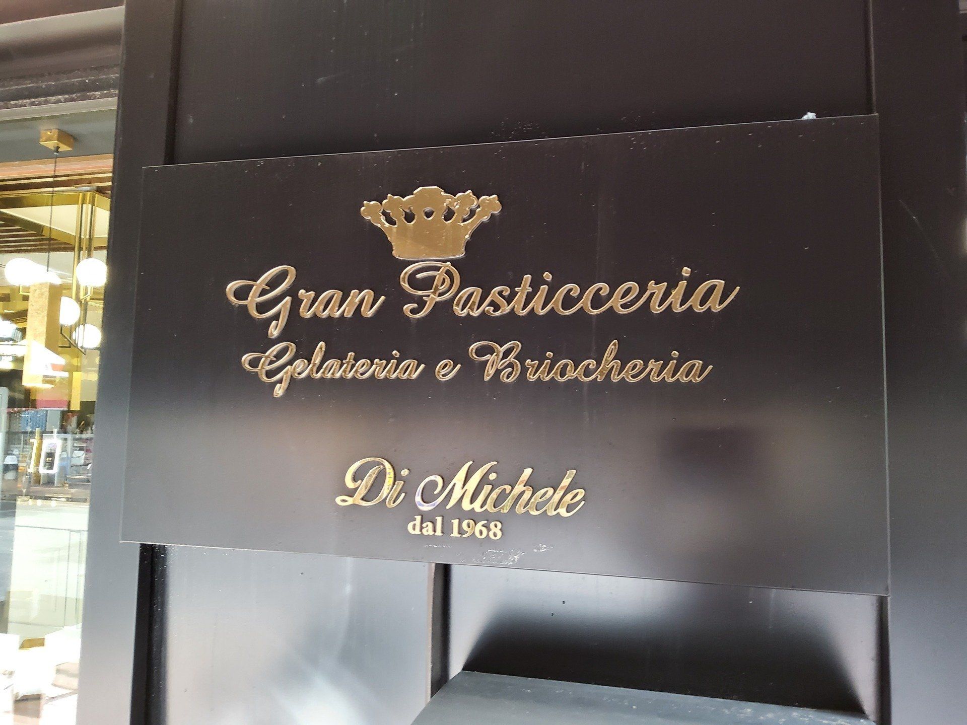 Insegna nera con scritta dorata per la pasticceria