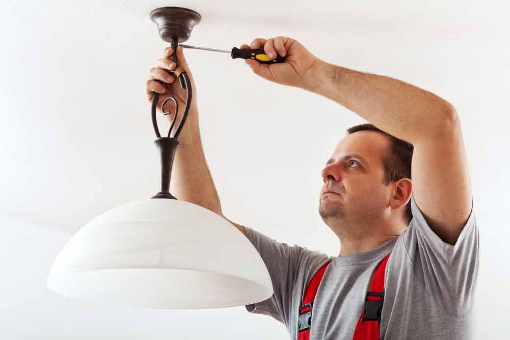 Electrician Mounting Ceiling Lamp — Level 2 Electrician in Toukley, NSW