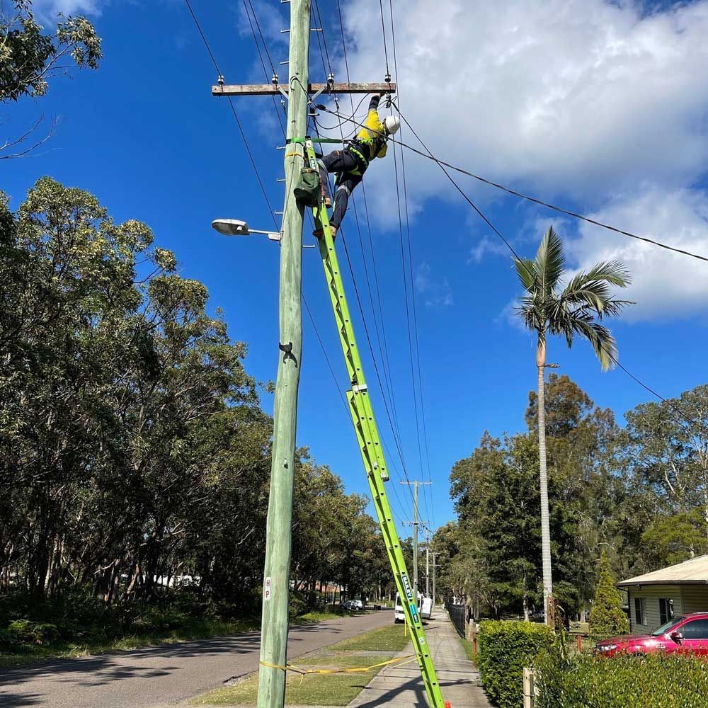 Electrician Working on a Powerline — Level 2 Electrician in Toukley, NSW
