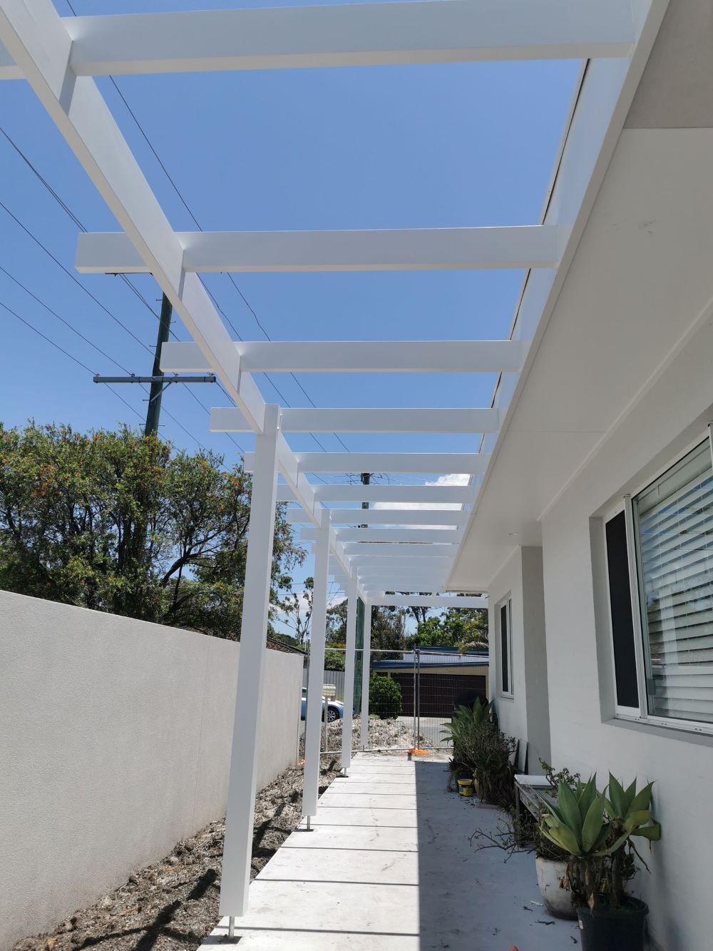 A White House With a Walkway Underneath It — Eva Professional Painting in Palm Beach, QLD