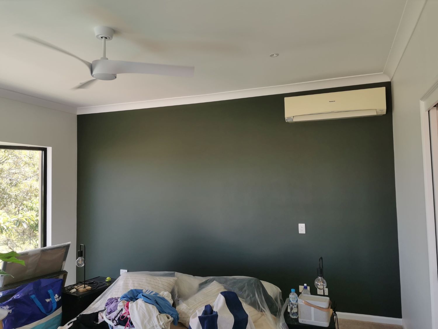 A Bedroom With a Bed and a Ceiling Fan — Eva Professional Painting in Robina, QLD