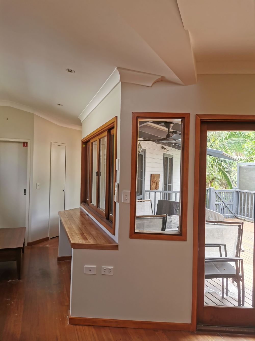 A Living Room With Hardwood Floors and a Sliding Glass Door — Eva Professional Painting in Robina, QLD