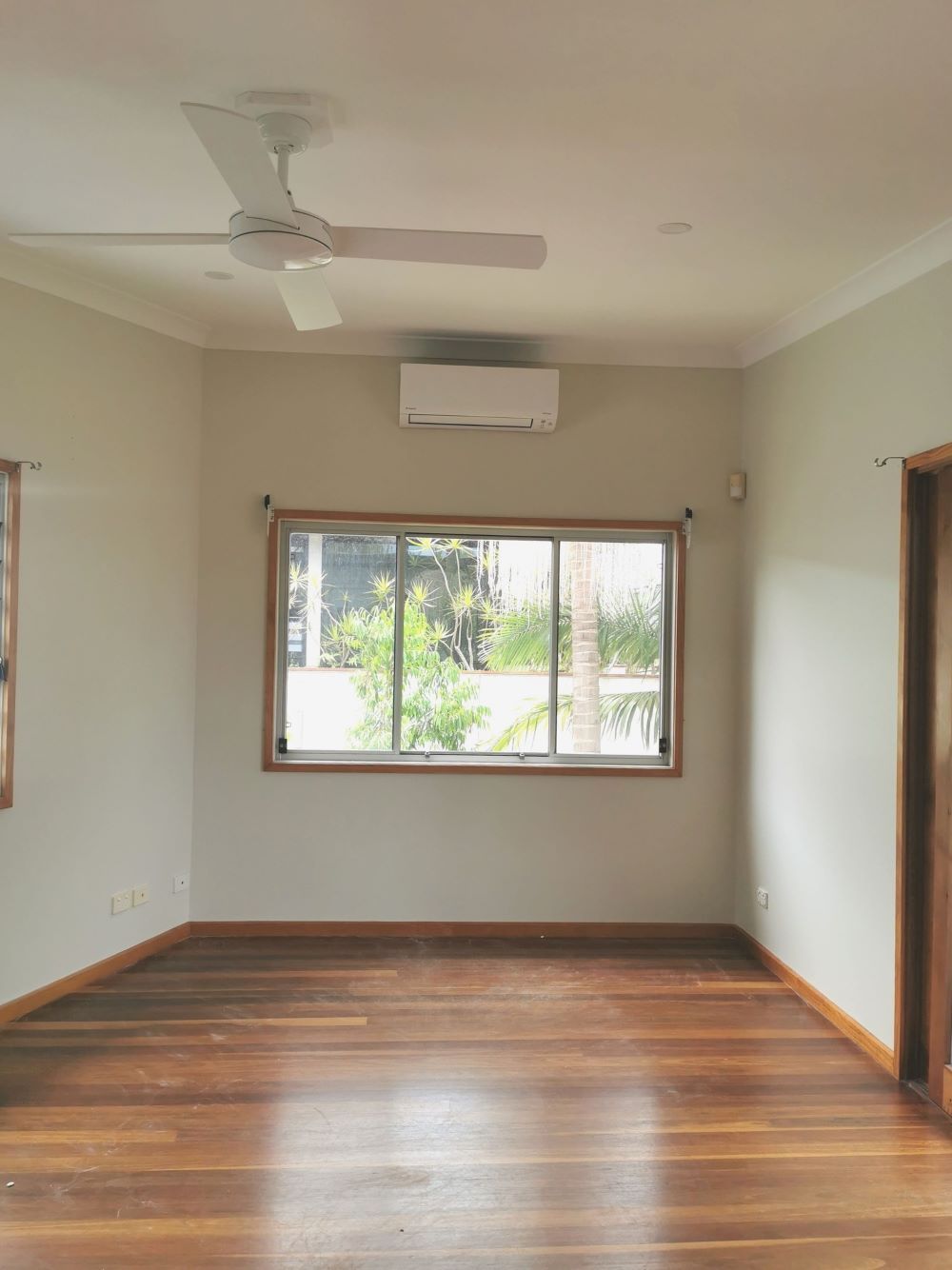 An Empty Room With a Ceiling Fan and a Window — Eva Professional Painting in Robina, QLD