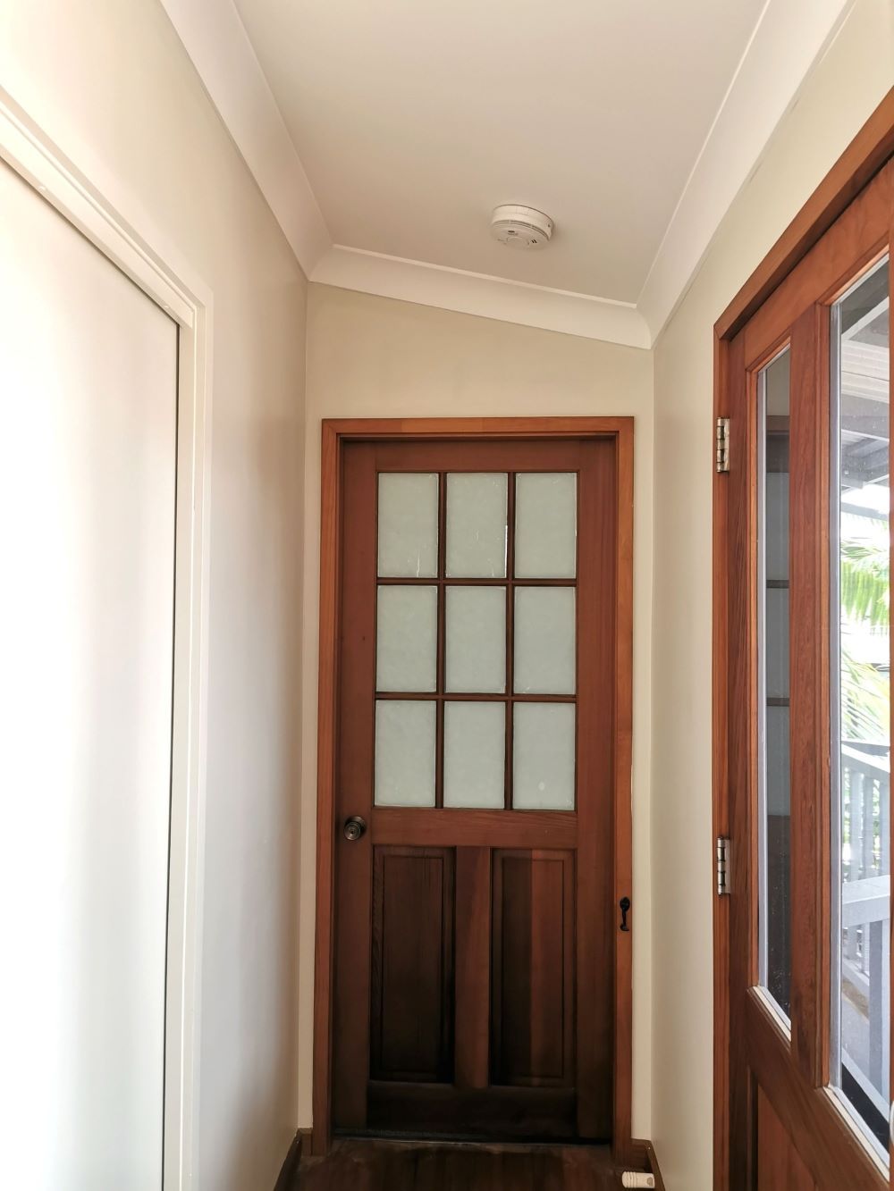 A Hallway With a Wooden Door and a Glass Door — Eva Professional Painting in Robina, QLD