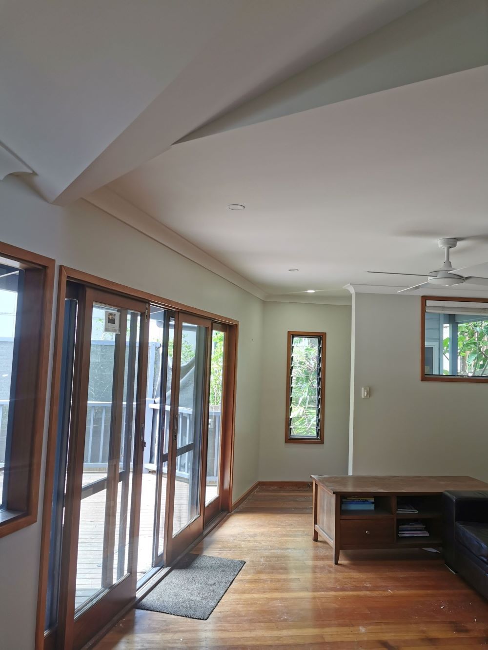 A Living Room With Sliding Glass Doors and a Ceiling Fan — Eva Professional Painting in Robina, QLD